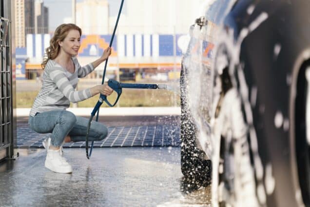 A woman washing her car outdoors