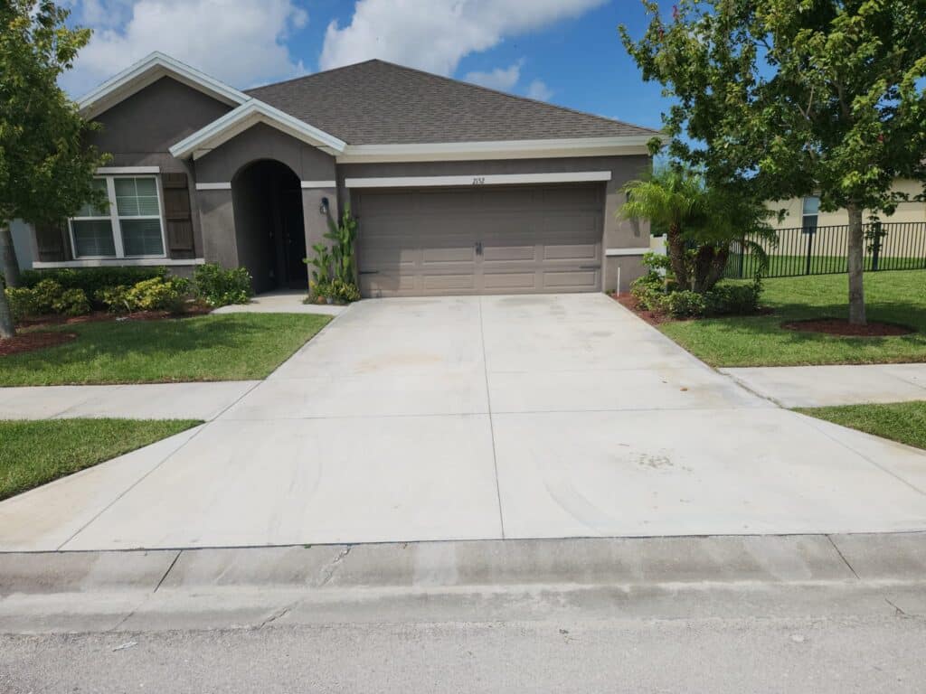 An unsoiled driveway and a beautiful brown house