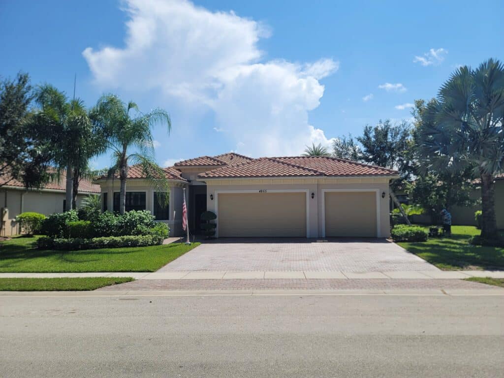 A clean driveway and a beige garage