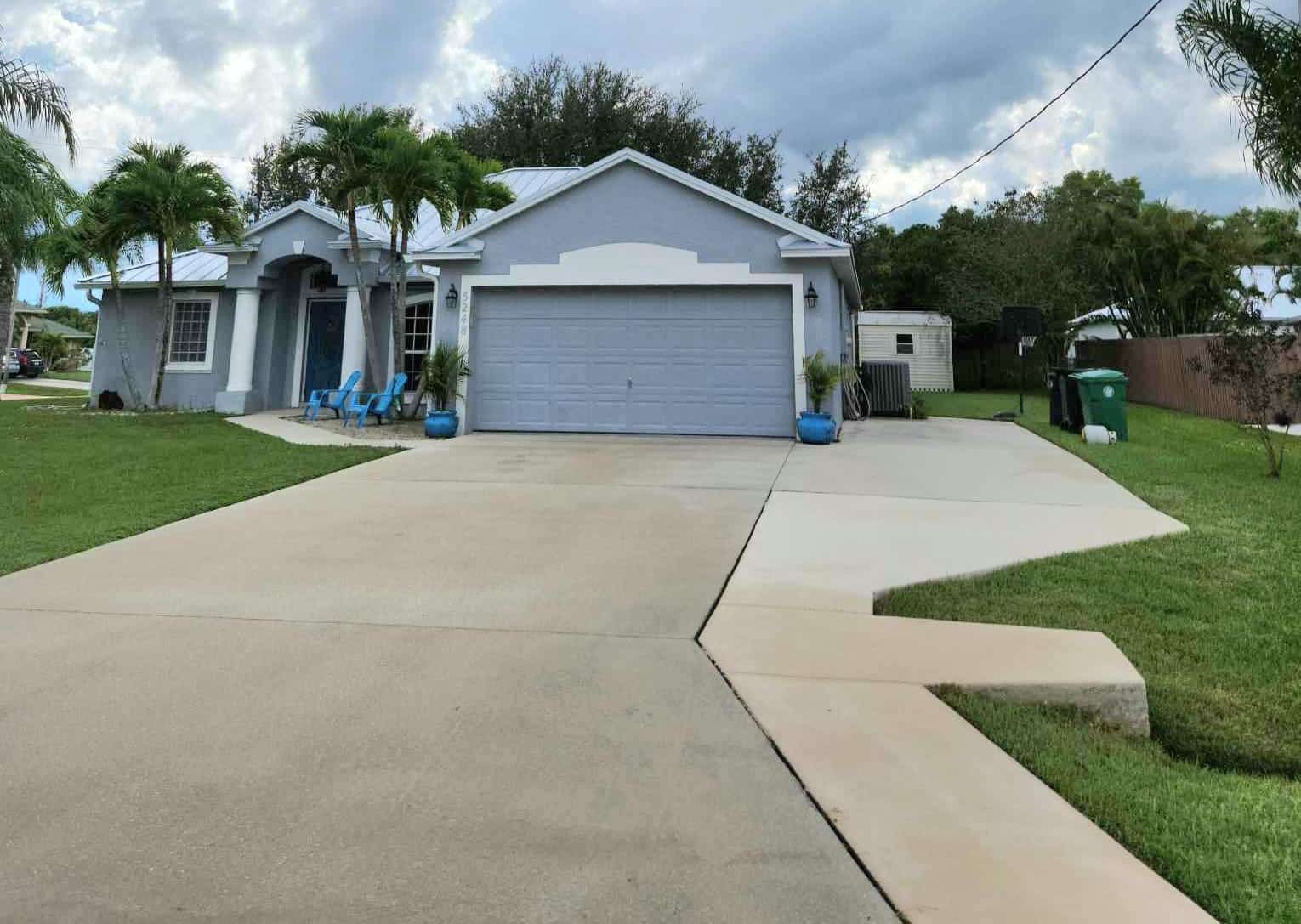 A clean driveway with a powder blue garage