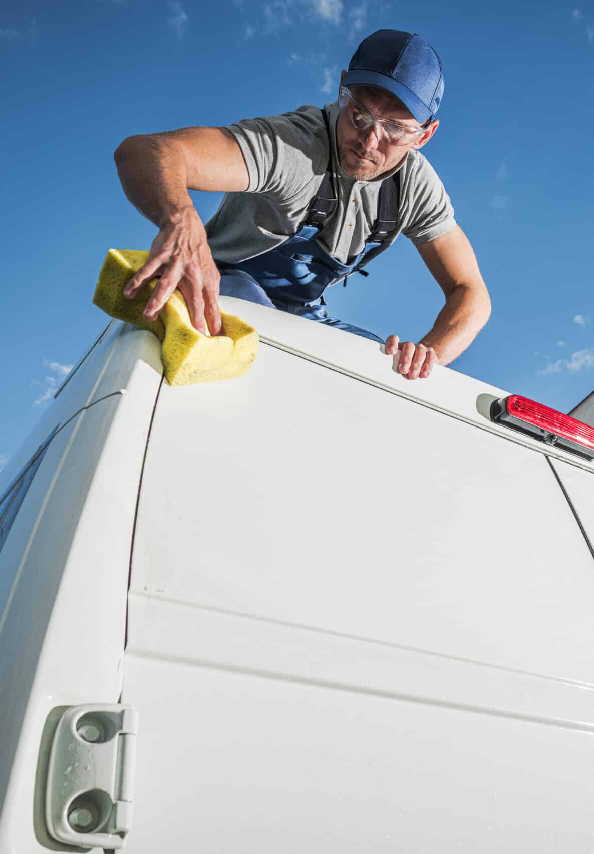 A man wiping an van's exterior